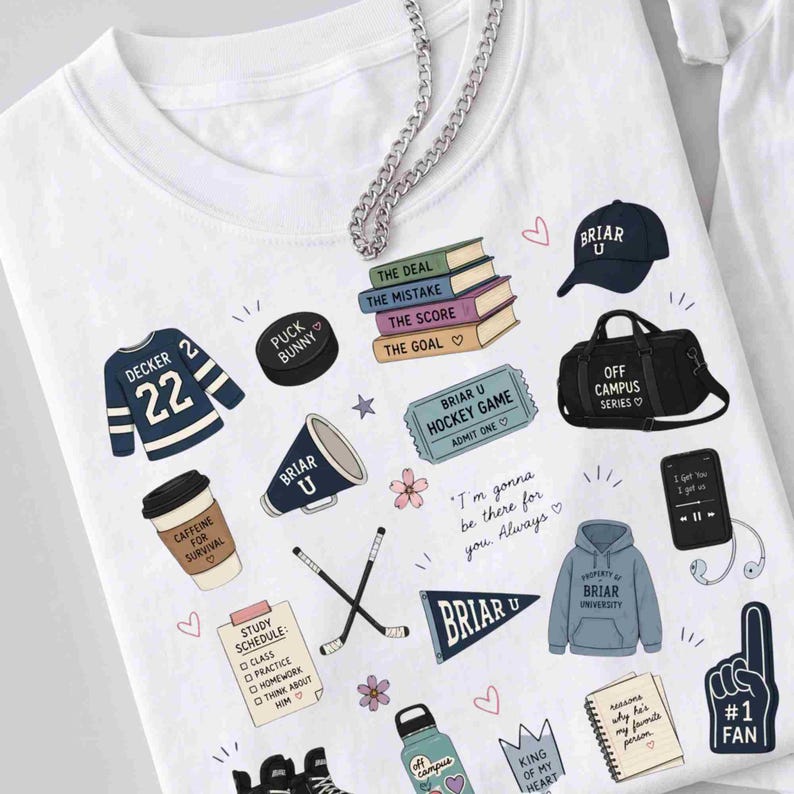 Puede incluir: Camiseta blanca con varios gr&aacute;ficos ilustrados, incluyendo una camiseta de hockey, libros, un disco de hockey, un meg&aacute;fono y una bolsa de deporte. La camiseta presenta el texto "Briar U" y otras frases. Una cadena plateada est&aacute; sobre la camiseta.