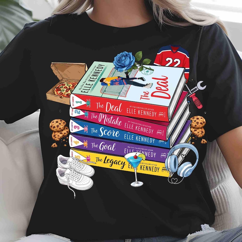 May include: Black t-shirt with a design featuring books by Elle Kennedy, including "The Deal" and "The Mistake". The image also shows a pizza box, cookies, trainers, a cocktail, and a hockey jersey. The design is colourful and eye-catching.