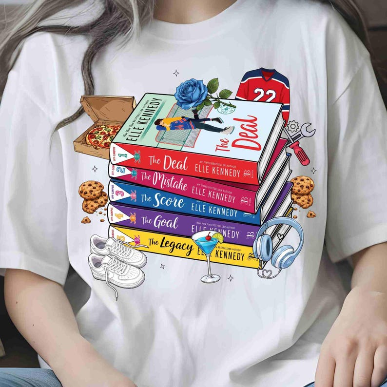 May include: White t-shirt with a design featuring a stack of books by Elle Kennedy, including "The Deal" and "The Mistake". The design also includes a hockey jersey, pizza, cookies, trainers, and a cocktail.
