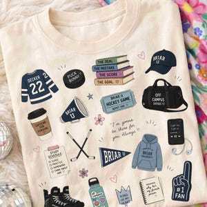 Puede incluir: Camiseta color crema con varios gr&aacute;ficos tem&aacute;ticos de hockey. Incluye una camiseta con "Decker 22", un disco de hockey, libros, una gorra, una bolsa de deporte, un meg&aacute;fono, palos de hockey, una botella de agua y un dedo de espuma. Texto con "Briar U".