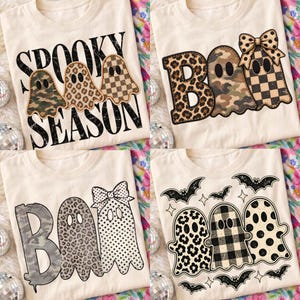 May include: Four cream-colored t-shirts featuring Halloween-themed graphics. Designs include ghosts with camouflage, leopard, and checkered patterns, the text "SPOOKY SEASON" and "BOO," plus decorative bows and black bat illustrations.