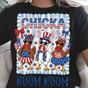 Puede incluir: Camiseta negra con un dise&ntilde;o patri&oacute;tico que presenta tres pollos de dibujos animados vestidos con trajes rojos, blancos y azules. El texto "CHICKA BOOM BOOM" se muestra en una fuente festiva, ideal para el D&iacute;a de la Independencia.