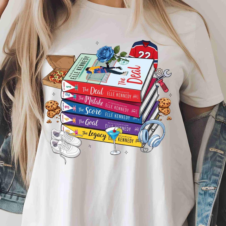 May include: White t-shirt with a design featuring a stack of books with titles including "The Deal" and "The Mistake" by Elle Kennedy. The design also includes a hockey jersey, pizza, and sneakers.