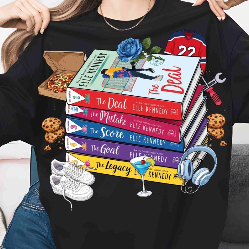 May include: Black t-shirt with a design featuring a stack of books titled "The Deal", "The Mistake", "The Score", "The Goal", and "The Legacy" by Elle Kennedy. The design includes a pizza box, cookies, trainers, a cocktail, and a hockey jersey.
