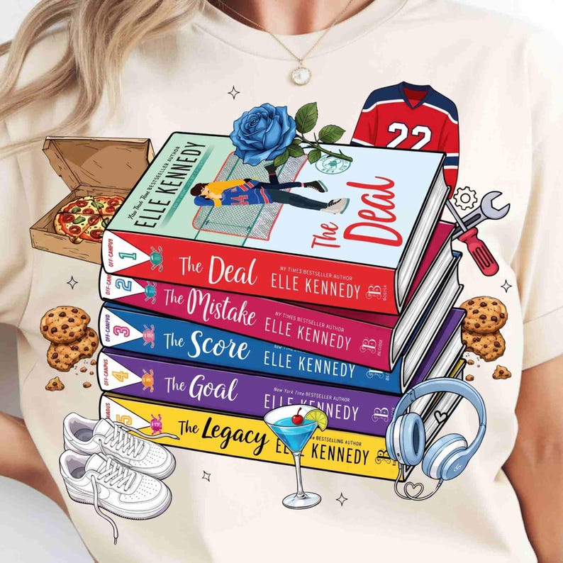 May include: A cream t-shirt design featuring a stack of books with titles including "The Deal" and "The Mistake" by Elle Kennedy. The design incorporates a hockey jersey, pizza, cookies, trainers, a cocktail, and headphones, along with a blue rose.