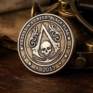 Może przedstawiać: Okrągła, metalowa moneta w kolorze brązu z logo Assassin's Creed: Black Flag, centralnym emblematem czaszki, ozdobnymi detalami filigranowymi oraz rokiem 2013 wytłoczonym na dolnej krawędzi, wykończona teksturowaną, postarzaną powierzchnią.