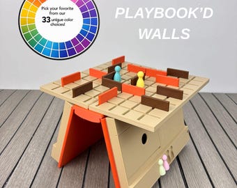 May include: A beige board game titled PLAYBOOK'D WALLS with a grid surface, orange and brown rectangular wall pieces, and small coloured game pawns. A circular colour wheel graphic displays the text Pick your favourite from our 33 unique colour choices.