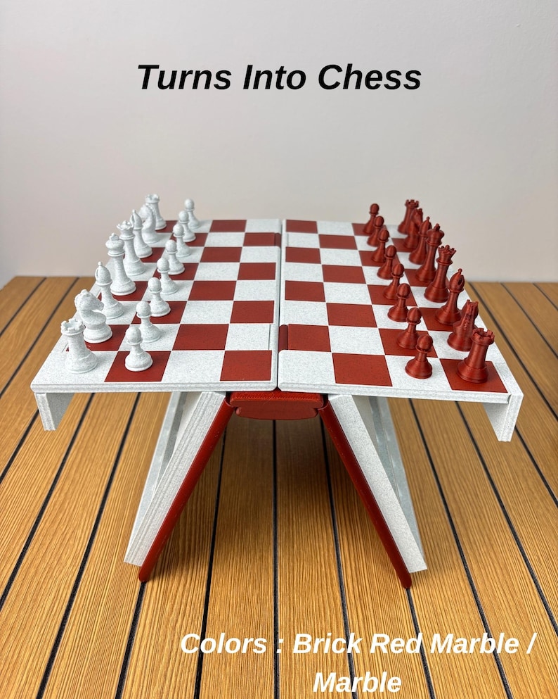 K&ouml;nnte beinhalten: Ein klappbares Schachspiel mit einem Brett in einem wei&szlig;-ziegelroten Schachbrettmuster. Das Set enth&auml;lt wei&szlig;e und ziegelrote Schachfiguren, die auf dem Brett angeordnet sind. Der Text 'Turns Into Chess' und 'Colors : Brick Red Marble / Marble' ist sichtbar.