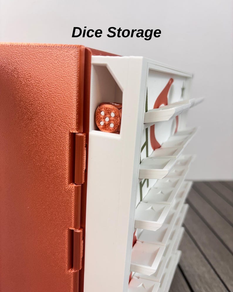 May include: A copper-colored dice storage case with a white side panel featuring multiple horizontal slots. The text Dice Storage is printed at the top. A single copper die with white pips is visible in the top slot of the white section.