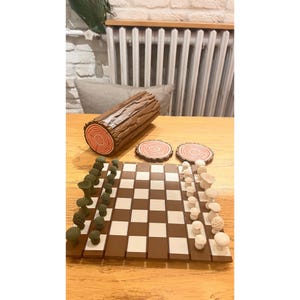 K&ouml;nnte beinhalten: Ein Schachspiel mit Waldthema. Das Brett ist braun und wei&szlig;, die Figuren sind wie Pilze und B&auml;ume geformt. Enth&auml;lt eine holzf&ouml;rmige Box und zwei Untersetzer.