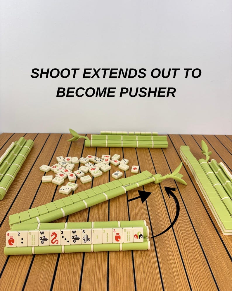 May include: A Mahjong set featuring light green tile racks designed to look like bamboo stalks. The racks include an extendable pusher arm. The text SHOOT EXTENDS OUT TO BECOME PUSHER is visible above the tiles and racks on the surface.