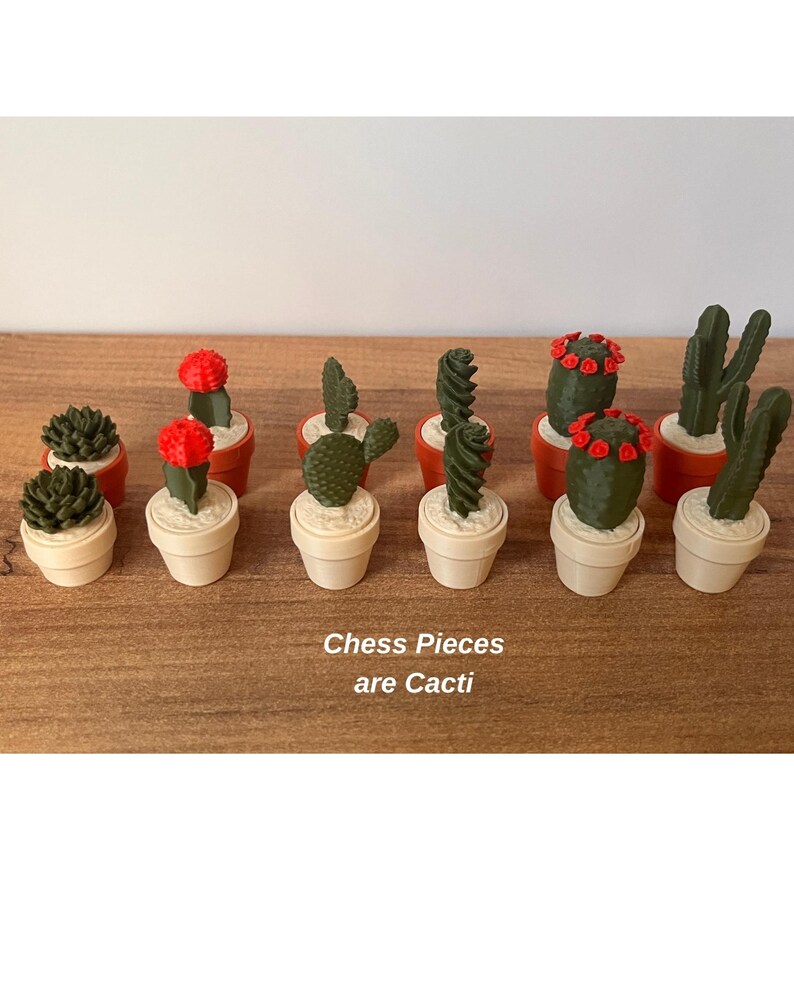 K&ouml;nnte beinhalten: Eine Sammlung von Miniatur-Schachfiguren in Form verschiedener gr&uuml;ner Kakteen in kleinen beigen und orangefarbenen T&ouml;pfen. Einige Kakteen haben leuchtend rote Bl&uuml;ten. Der Text "Chess Pieces are Cacti" ist in Wei&szlig; auf die Holzoberfl&auml;che gedruckt.