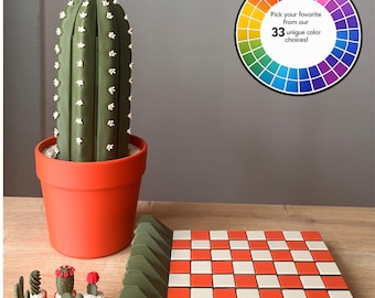 May include: A large green cactus in an orange pot, six miniature cacti in small pots, and a square tray with an orange and white checkered pattern. A circular color wheel graphic displays the text: Pick your favorite from our 33 unique color choices!