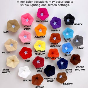 May include: A collection of twenty-four flower-shaped hair clips in various colors including magenta, vivid pink, orange, purple, black, oak, pink, burnt orange, light blue, gray, beige, banana yellow, sky blue, red, terracotta, dark red, navy, coffee brown, white, bone white, midnight blue, stone brick, and brown.