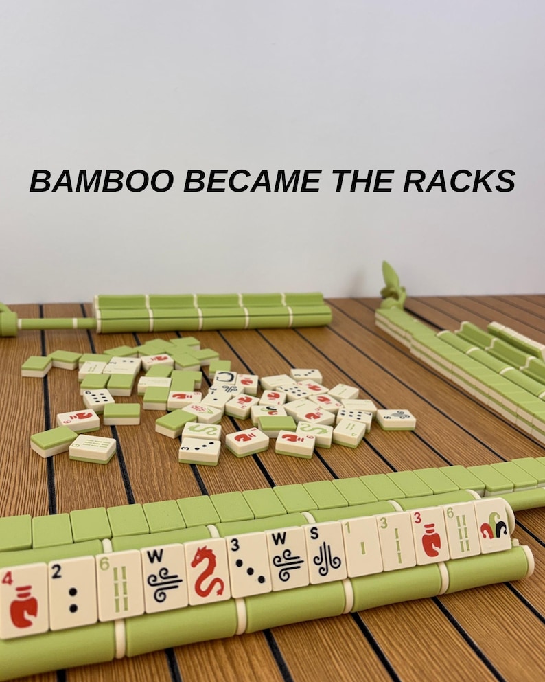 May include: A Mahjong game set featuring light green racks and tiles with red, black, and green symbols. The text BAMBOO BECAME THE RACKS is visible above the game pieces. The tiles are scattered in the center with racks positioned around them.