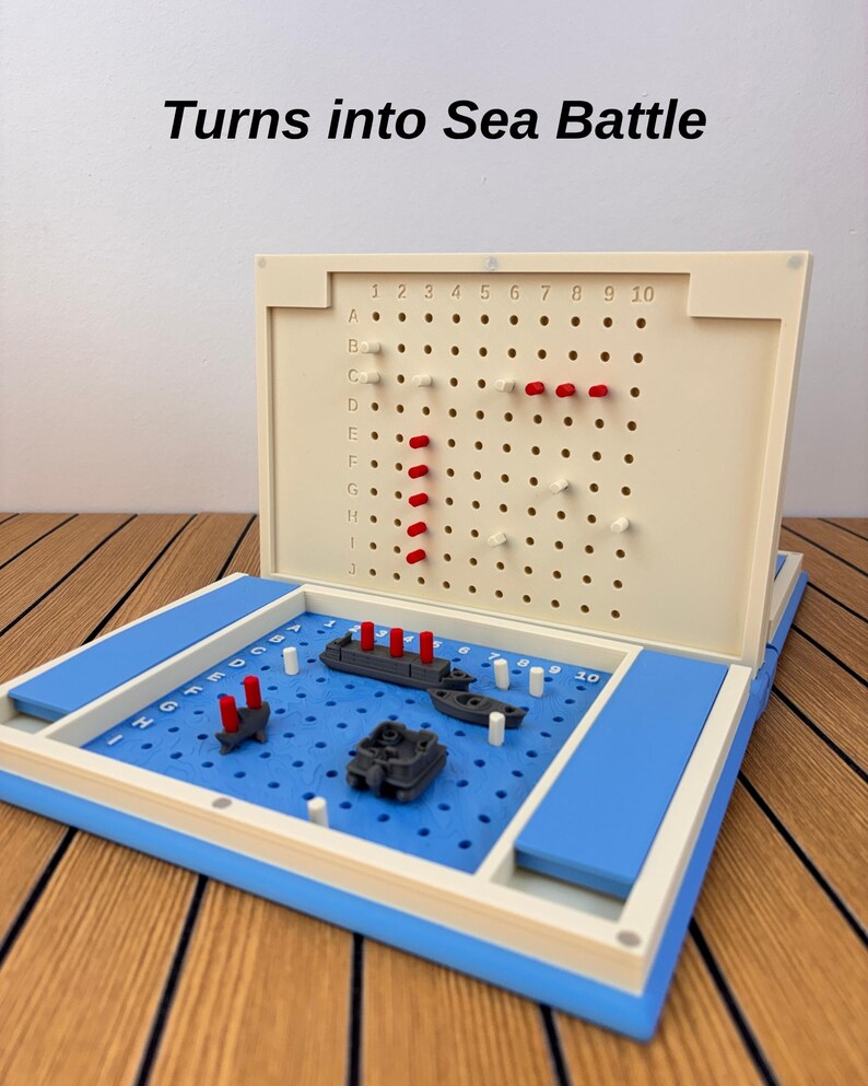 May include: A board game featuring a blue grid base with gray plastic ships and red pegs, and a cream-colored vertical grid board with rows A-J and columns 1-10. The text 'Turns into Sea Battle' is printed above the game board in black font.