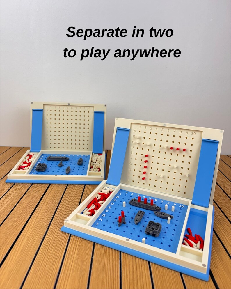 May include: A two-part strategy board game featuring a blue and cream plastic grid with the text Separate in two to play anywhere. The game includes gray miniature ships, red and white pegs for tracking hits and misses on a vertical board.