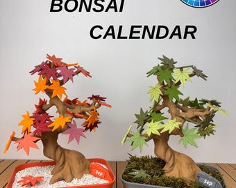 May include: Two bonsai calendar sculptures with brown trunks and leaf-shaped pieces. The left tree has orange and red leaves in an orange pot with white gravel. The right tree has green leaves in a grey pot with moss. Text reads BONSAI CALENDAR.