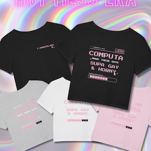 May include: A collection of short-sleeved t-shirts in black, white, grey, and light pink. Each shirt features a pixelated computer window graphic with the text "COMPUTA.EXE", "MAKE THESE GUYS SUPA GAY & HORNY", and a loading bar. The top text reads "HOT MESS ERA".