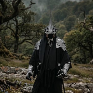 May include: A person in a black robe and silver armour stands in a forest. The costume features a detailed helmet with a tall spike and a menacing mask. Two swords are visible, suggesting a fantasy or cosplay theme.