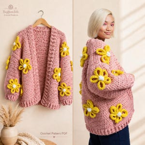 Könnte beinhalten: Ein rosa gehäkelter Cardigan, verziert mit gelben und weißen Blumenapplikationen. Der offene Pullover wird auf einem Holzbügel präsentiert. Das Bild zeigt auch eine Person, die den Cardigan trägt. Der Text "Crochet Pattern PDF" ist sichtbar.