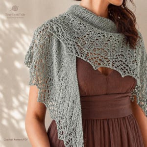 May include: A light gray crocheted shawl with a delicate openwork design. The shawl is draped over the shoulders and chest. The image includes the text "Tiny Yarn Tale Crochet Patterns" and "Crochet Pattern PDF".