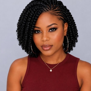 May include: A dark red sleeveless ribbed top paired with a delicate gold chain necklace featuring a small circular pendant and large gold hoop earrings. The hair is styled in short, black, tightly coiled braids with a side-swept parting.