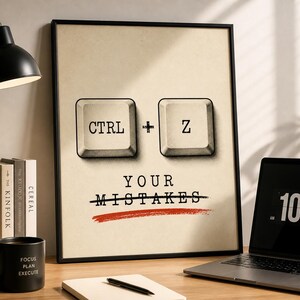 Pode incluir: Impressão emoldurada com fundo bege. Apresenta teclas de teclado com as letras "CTRL" e "Z", com o texto "YOUR MISTAKES" abaixo, riscado com uma linha vermelha. Uma caneca preta, livros e um laptop também são visíveis.