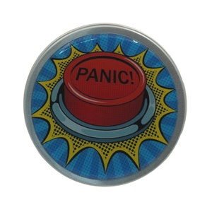 May include: A round, silver-colored tin with a red button that says "PANIC!" in black letters. The button is surrounded by a yellow starburst on a blue background.
