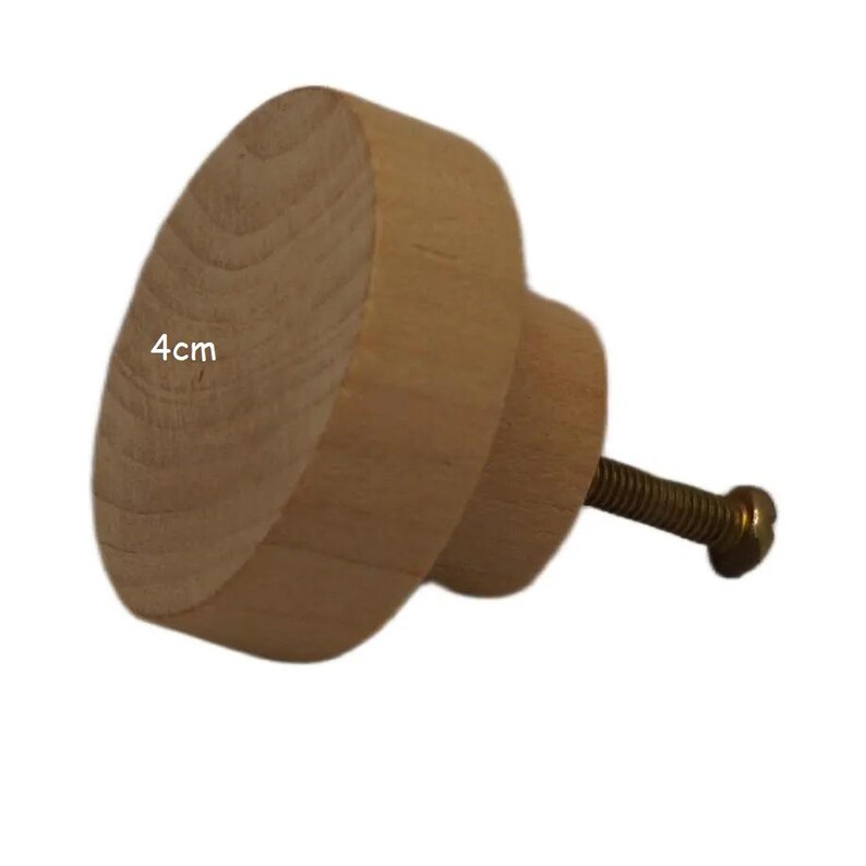 K&ouml;nnte beinhalten: Ein hellfarbiger Holzschrankknopf mit einer Schraube. Der Knopf hat einen Durchmesser von 4 cm und eine abgerundete Form. Die Schraube ist goldfarben.