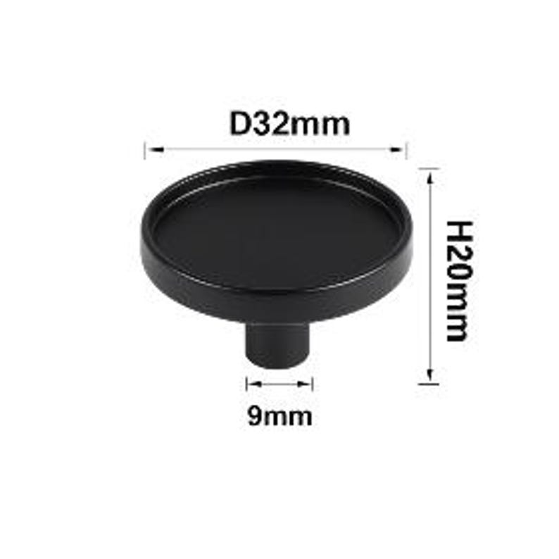 May include: A black cabinet knob with a round tray-like top. The knob measures 1.26 inches in diameter and 0.79 inches in height. The stem is 0.35 inches wide. The knob is designed for easy installation on drawers and cabinets.