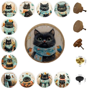 Könnte beinhalten: Eine Sammlung dekorativer Schrankknöpfe und Schubladengriffe. Die Knöpfe zeigen eine schwarze Katze mit blauem Schal und Vögeln sowie Knöpfe aus Holz und Messing. Der Messingknopf hat einen Durchmesser von 32 mm und ist 20 mm hoch.