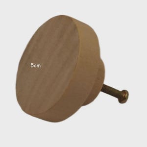 May include: A round, light-coloured wooden cabinet knob with a smooth, flat front surface. The knob features a metal screw extending from the back for attachment. The text 5cm is printed on the front face, indicating a diameter of 5 centimetres.