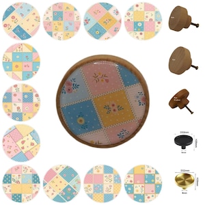 Könnte beinhalten: Eine Sammlung dekorativer Schrankknöpfe mit Patchwork-Design. Die Knöpfe weisen eine Vielzahl von Pastellfarben auf, darunter Rosa, Blau, Gelb und Weiß, mit Blumen- und Tupfenmustern. Es werden auch mehrere Holzknöpfe sowie schwarze und goldfarbene Metallknöpfe gezeigt.