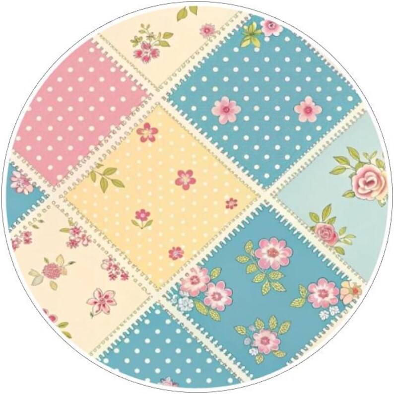 K&ouml;nnte beinhalten: Ein rundes Patchwork-Design mit Quadraten aus rosa, gelbem und blauem Stoff. Die Quadrate sind mit wei&szlig;en Tupfen und floralen Mustern in Rosa und Gr&uuml;n verziert. Die Kanten sind mit einem wei&szlig;en Zickzackmuster gen&auml;ht.