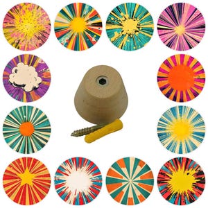 May include: A collection of colorful, circular decorative knobs with a retro comic book style. The knobs feature various designs, including starbursts, explosions, and a cloud. A wooden knob, screw, and wall anchor are also included.