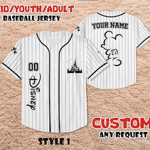 May include: White baseball jersey with black pinstripes, featuring the word "Disney" in script, the number "00", and a castle silhouette. The back of the jersey has the text "YOUR NAME" and a Mickey Mouse outline. The jersey is labeled "KID/YOUTH/ADULT BASEBALL JERSEY".