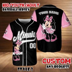 May include: Black baseball jersey with pink sleeves featuring a Minnie Mouse design. The jersey has the word "Minnie" in white script, the number "00", and the text "KID/YOUTH/ADULT BASEBALL JERSEY". The back of the jersey has the text "YOUR NAME" and a Minnie Mouse graphic.