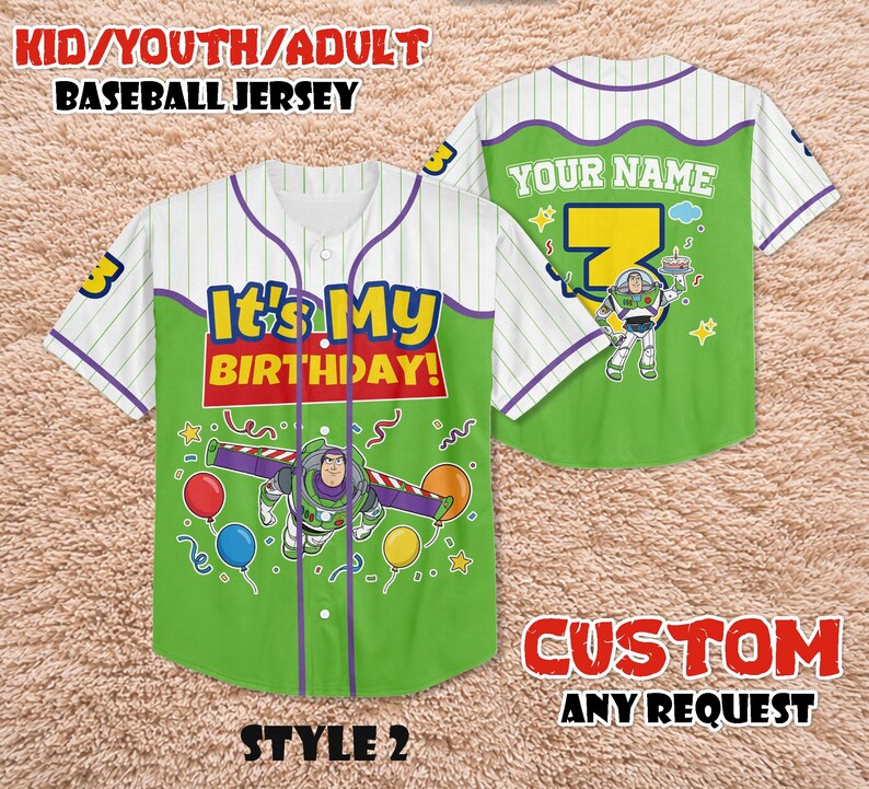 May include: A green and white baseball jersey with the text "It's My Birthday!" and a Buzz Lightyear graphic. The jersey has purple accents and the text "YOUR NAME" on the back. The jersey is for kids, youth, or adults.
