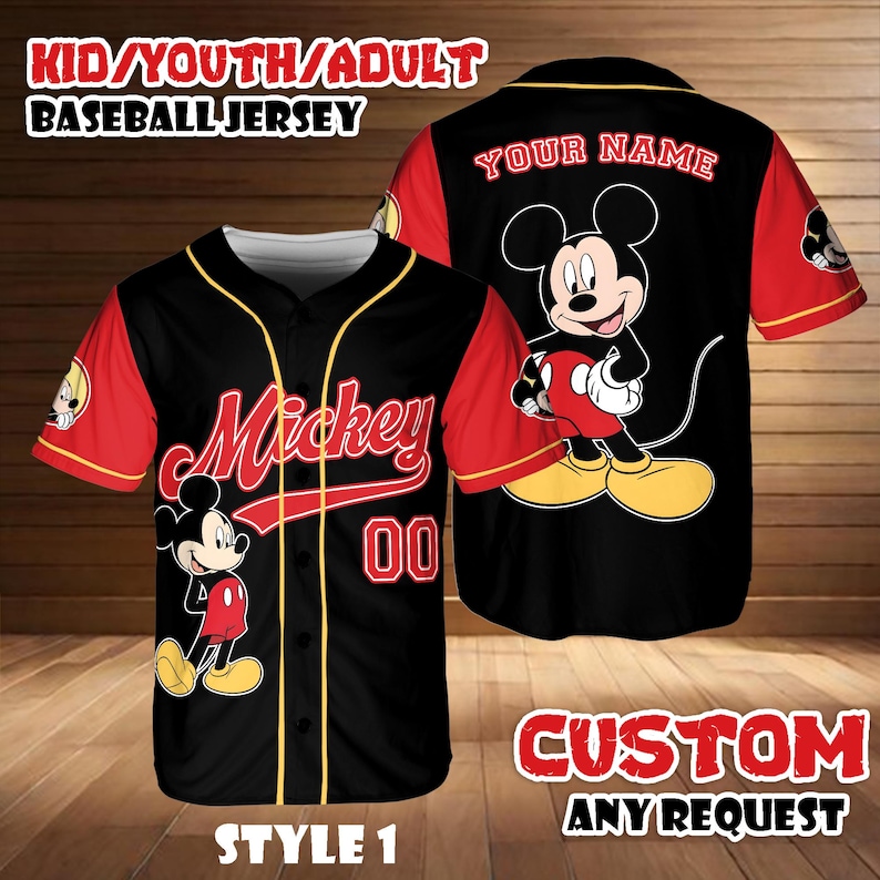 May include: Black baseball jersey with red sleeves and yellow trim. Features the name "Mickey" in red script, the number "00", and a Mickey Mouse graphic. The back of the jersey has a large Mickey Mouse graphic and the text "YOUR NAME". The jersey is labeled "STYLE 1".