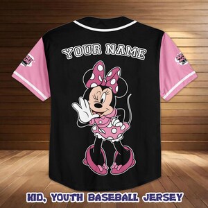 May include: Black baseball jersey with pink sleeves and white trim. Features a Minnie Mouse graphic on the back, with the text "YOUR NAME" above the graphic. The text "KID, YOUTH BASEBALL JERSEY" is at the bottom.
