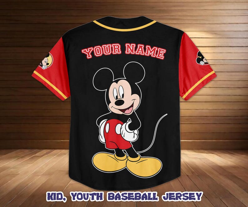 May include: Black baseball jersey with red sleeves and yellow trim. Features a large Mickey Mouse graphic on the front and the text "YOUR NAME" in red. The jersey also has the text "KID, YOUTH BASEBALL JERSEY" at the bottom.