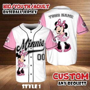 May include: White baseball jersey with pink sleeves featuring a Minnie Mouse graphic. The jersey has the word "Minnie" in black script, the number "00", and the text "KID/YOUTH/ADULT BASEBALL JERSEY". The back of the jersey has the text "YOUR NAME".