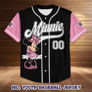 May include: Black baseball jersey with pink sleeves and white trim. Features a Minnie Mouse graphic and the name "Minnie" in white script. The number "00" is displayed on the front. The text "KID, YOUTH BASEBALL JERSEY" is at the bottom.