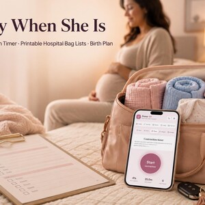 May include: A beige hospital bag containing rolled pink and blue blankets, a pink baby hat, and a white onesie. A smartphone displays a contraction timer app, and a clipboard with a printed checklist sits nearby. Text reads Ready When She Is.
