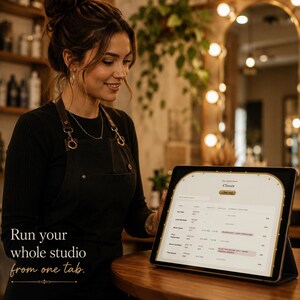 May include: A black tablet displaying a digital client management interface with a list of names, dates, and financial data. The screen features the text 'Clients' and 'Run your whole studio from one tab.' The device is positioned on a wooden surface.
