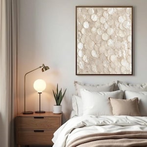 May include: A rectangular wall art piece featuring a dense, overlapping pattern of circular, iridescent white shell discs. The artwork is framed in a thin, dark brown border and displays a textured, shimmering surface with natural pearlescent tones.