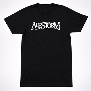 Puede incluir: Camiseta negra con el texto blanco "ALESTORM" en el pecho. El texto está en una fuente estilizada. La camiseta tiene mangas cortas y cuello redondo.