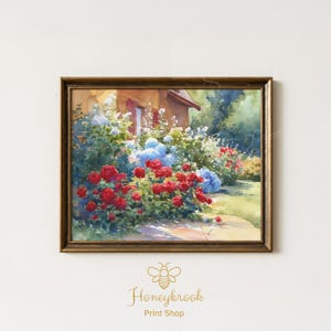 Pode incluir: Uma impressão em aquarela emoldurada de uma cena de jardim. A obra apresenta uma casa com persianas vermelhas, rodeada por rosas vermelhas, hortênsias azuis e flores brancas. A moldura é de cor castanho quente.