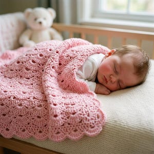 May include: A soft, light pink crochet baby blanket featuring a repeating scalloped shell pattern with a decorative scalloped edge. The blanket is draped over a sleeping infant wearing a white long-sleeved shirt, with a plush teddy bear nearby.